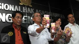 Ketua PP Muhammadiyah, Busyro Muqoddas menunjukkan sejumlah uang saat memaparkan hasil autopsi jenazah terduga teroris asal Klaten, Siyono di Jakarta, Senin (11/4). Uang senilai Rp 100 juta itu diberikan oleh pihak Polri. (Liputan6.com/Helmi Affandi)