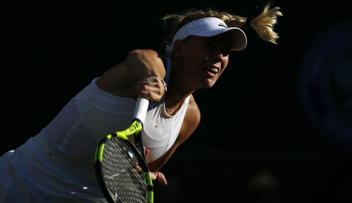Ekspresi petenis Denmark, Caroline Wozniacki saat mengembalikan bola ke arah lawannya petenis Hungaria, Timea Babos pada laga tunggal putri Wimbledon 2017 di Wimbledon Tennis Championships, London, (4/7/2017). (AP/Alastair Grant)