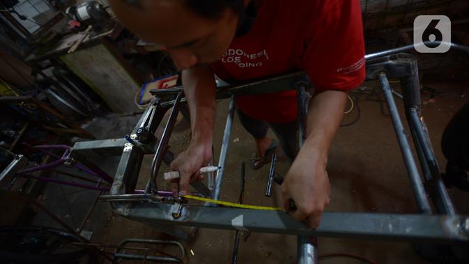 Pemilik workshop Alam Project, Alam menyelesaikan pembuatan sepeda multiguna atau kargo di bengkelnya kawasan Tangerang Selatan, Sabtu (10/7/2020). Harga sepeda kargo dipatok Rp3-8 juta tergantung jenis dan ukuran sepeda. (merdeka.com/Imam Buhori)