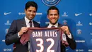 Dani Alves berpose dengan Presiden PSG Nasser Al-Khelaifi saat konferensi pers di stadion Parc des Princes di Paris, Prancis, (12/7). Alves akan mengenakan seragam nomor punggug 32, sama seperti yang dipakainya di Juventus. (AP Photo/Michel Euler)