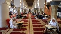 Umat Muslim berkumpul untuk membaca Al-qur'an pada hari pertama bulan suci Ramadhan di Masjid Al-Kabir di kota tua Sanaa, ibu kota Yaman, 2 April 2022. Pada bulan Ramadhan umat muslim memanfaatkan waktu untuk memperbanyak ibadah dengan membaca Al Quran. (MOHAMMED HUWAIS/AFP)