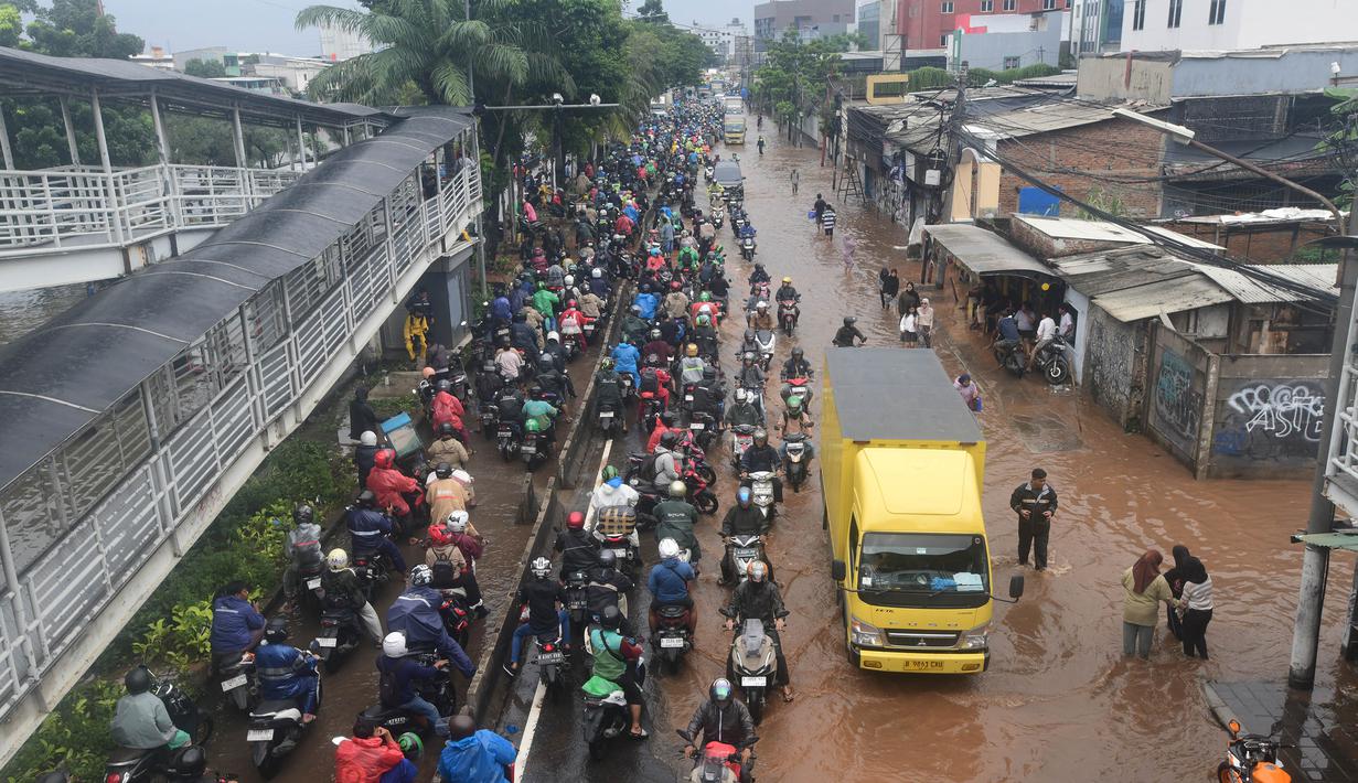 Badan Meteorologi, Klimatologi, dan Geofisika (BMKG) telah menetapkan status level awas untuk wilayah Jakarta Barat karena hujan lebat diprediksi masih akan terus berlangsung sepanjang Jumat 23 Januari 2026. Tampak dalam foto, antrean pengendara motor yang mencoba menerobos banjir di Jalan Daan Mogot, Jakarta, Jumat (23/1/02026). (merdeka.com/ Arie Basuki)