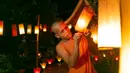 Biarawan menyalakan lentera di Luang Prabang, Laos, 3 Oktober 2020. Dalam Festival Boun Lai Heua Fai, warga melarung perahu naga dari batang pohon pisang yang membawa bunga, dupa, dan lilin menyusuri Sungai Mekong untuk membuang nasib buruk dan mengalirkan keberuntungan. (Xinhua/Kaikeo Saiyasane)
