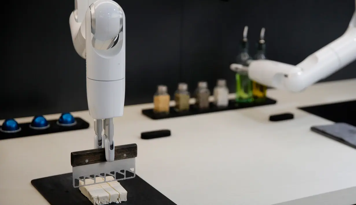 Samsung Bot Chef memotong tahu saat menunjukkan kemampuannya selama ajang  CES 2020 di Las Vegas, Nevada pada 8 Januari 2020. Samsung memamerkan robot koki canggih memiliki berbentuk lengan panjang yang bisa masak berbagai macam makanan. (AP/John Locher)