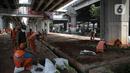 Petugas PPSU menanam pohon di kolong Tol Becakayu, Jakarta, Kamis (12/1/2023). Pemerintah Provinsi DKI Jakarta melakukan penataan lahan melalui program penghijauan sepanjang lima kilometer di tepi saluran Kalimalang  kolong tol Bekasi Cawang Kampung Melayu (Becakayu), Jakarta Timur untuk menjaga mutu air baku Jakarta. (Liputan6.com/Faizal Fanani)