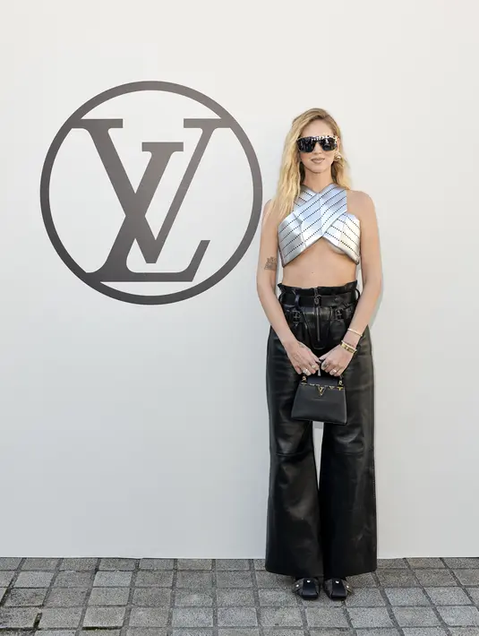 Artis dan fashion influencer Chiara Ferragni hadir di show Louis Vuitton mengenakan crossneck crop top berwarna silver. Dipadukan dengan leather pants yang trendy dan tas dari Louis Vuitton (Louis Vuitton)