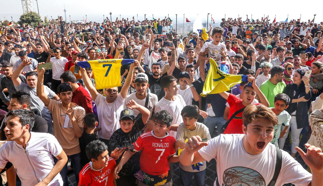 Sejumlah masyarakat Tehran membawa jersey Cristiano Ronaldo saat menyambut kedatangan Al-Nassr menjelang laga Liga Champions Asia 2023 melawan Persepolis FC, Selasa (19/09/2023). (AFP/Payam Parsae)