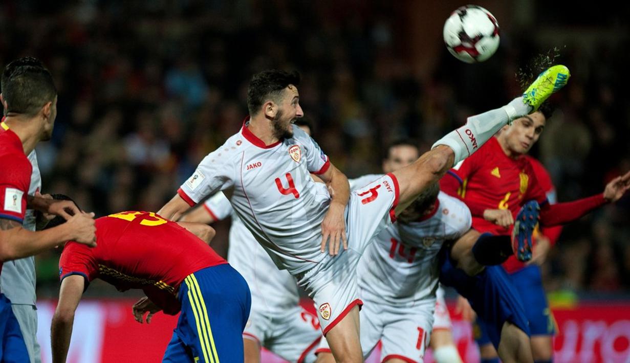 Pemain Makedonia, Kire Ristevski, berusaha membuang bola serangan pemain Spanyol dalam laga lanjutan Grup G Kualifikasi Piala Dunia 2018 di Estadio Nuevo Los Carmenes, Sabtu (12/11/2016) waktu setempat. (AFP/Jorge Guerrero)