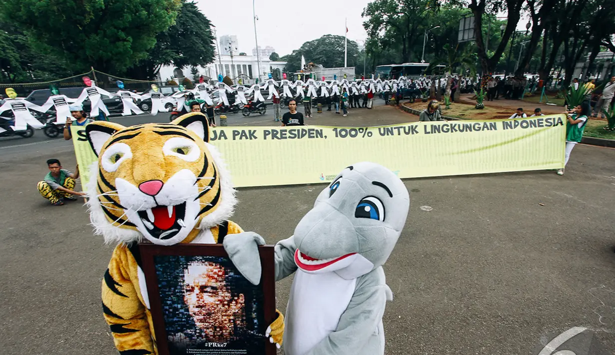 2 Aktivis Greenpeace memakai kostum harimau dan komodo saat beraksi depan Istana Merdeka, Jakarta, Senin (27/10/2014) (Liputan6.com/Faizal Fanani)