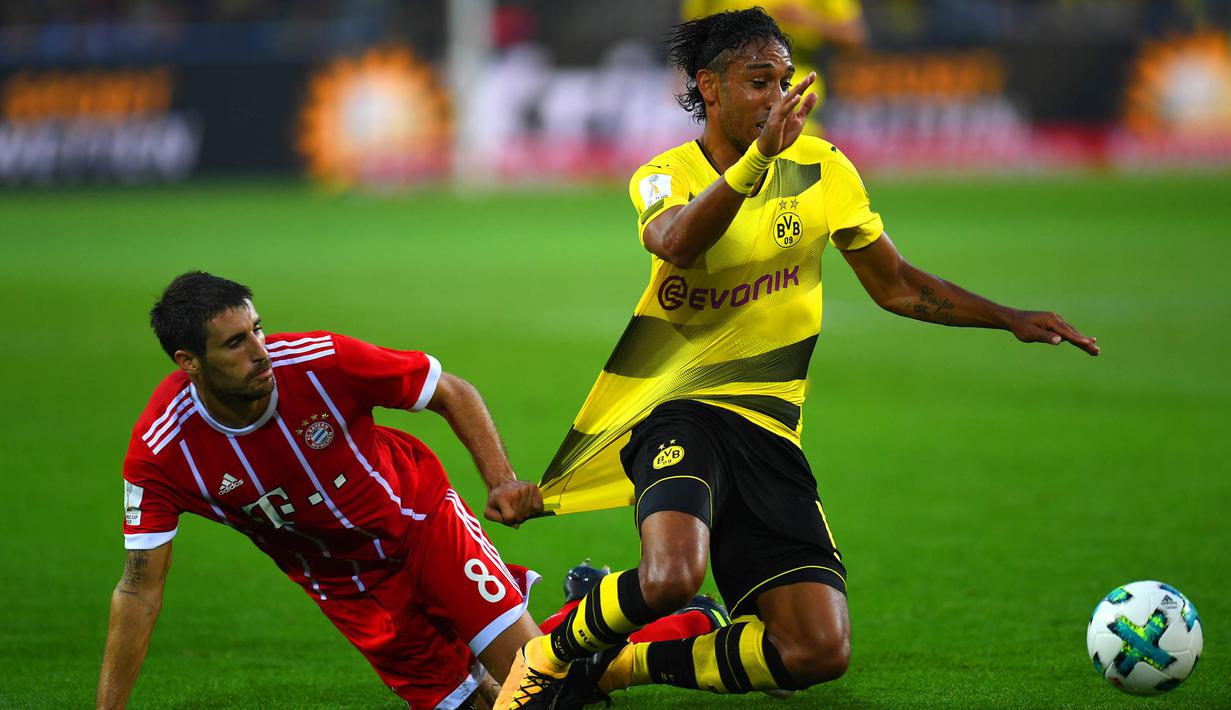 Gelandang Bayern Munchen, Javi Martinez, menarik striker Dortmund, Pierre-Emerick Aubameyang, pada laga Piala Super Jerman di Stadion Signal Iduna Park, Dortmund, Sabtu (5/8/2017). Munchen menang adu penalti 5-4 atas Dortmund. (AFP/Patrik Stollarz)
