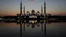 Matahari terbenam di belakang Masjid Agung Sheikh Zayed di Abu Dhabi, Uni Emirat Arab (8/11/2019). Masjid Agung Sheikh Zayed di bangun pada tahun 1996 dengan 82 kubah bergaya Maroko dan semuanya dihias dengan batu pualam putih. (AFP Photo/Kamran Jebreili)