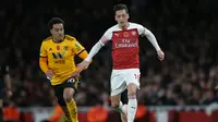 Aksi Mesut Ozil saat mengiring bola kontra Wolverhampton pada laga lanjutan Premier League, yang berlangsung Minggu (11/11) di stadion Emirates. Arsenal ditahan imbang Wolverhampton 1-1. (AFP/Daniel Olivas)