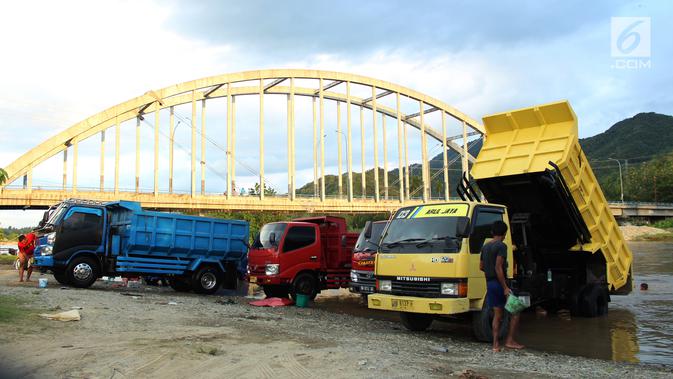 Sejumlah orang mencuci truk dengan memanfaatkan aliran sungai Bone di kompleks Jembatan Talumolo II, Kelurahan Talumolo, Gorontalo, Senin (19/11). Tempat itu menjadi kawasan pencucian kendaraan bermotor yang gratis.  (Liputan6.com/Arfandi Ibrahim)