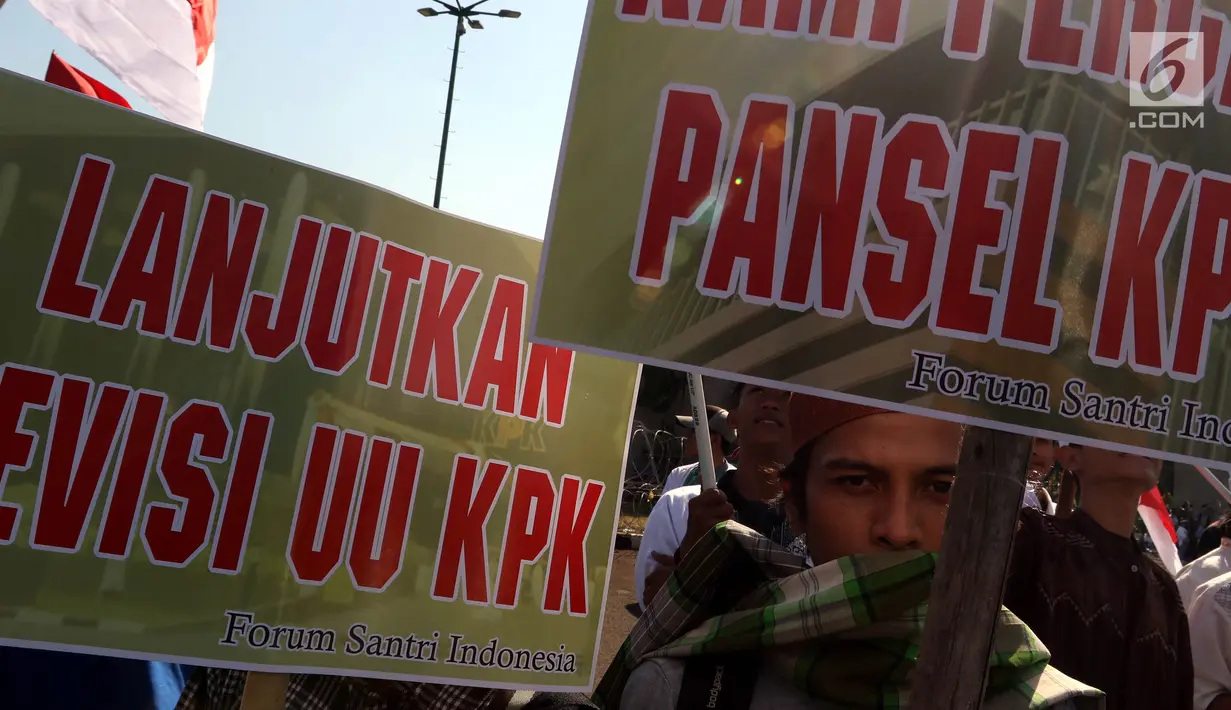 Massa membawa poster saat melakukan aksi mendukung Revisi UU KPK di depan Gedung DPR/MPR RI, Jakarta, Rabu (11/9/2019). Mereka menyuarakan pro dan kontra terhadap revisi Undang-Undang Nomor 30 Tahun 2002 tentang Komisi Pemberantasan Tindak Pidana Korupsi. (Liputan6.com/Johan Tallo)