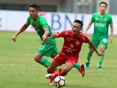 Penyerang Semen Padang, Adi Nugroho terjatuh saat berebut bola dengan bek Bhayangkara FC, Indra Kahfi di lanjutan Liga 1 Indonesia di Stadion Patriot Candrabhaga, Bekasi, Sabtu (20/5). Bhayangkara FC unggul 1-0. (Liputan6.com/Helmi Fithriansyah)