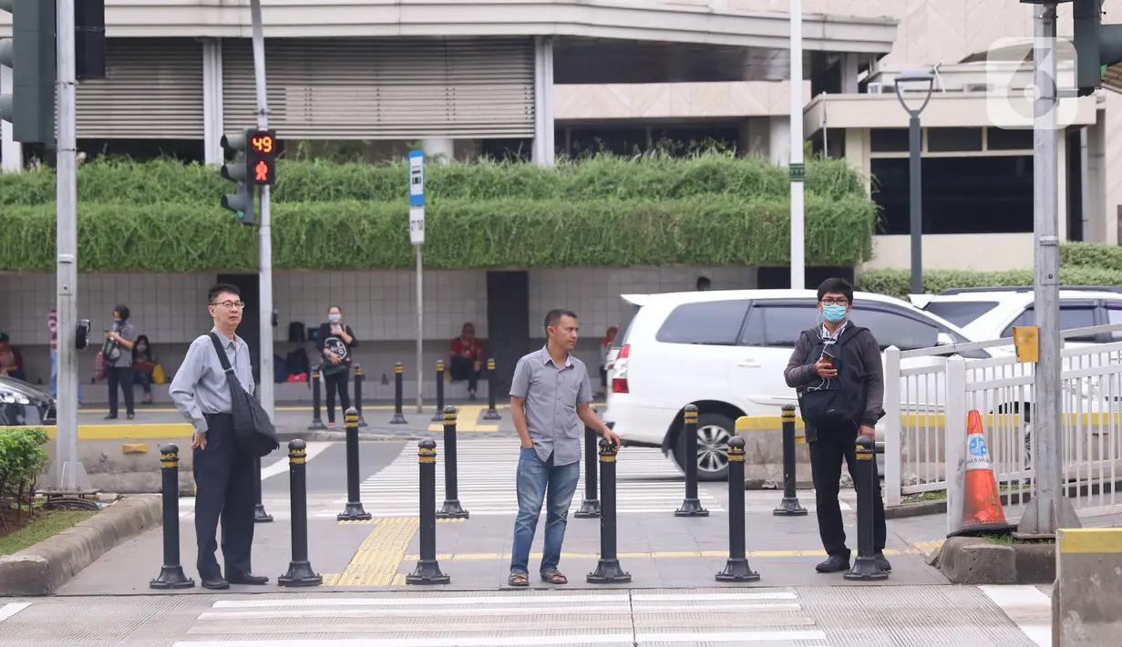 Sejumlah masyarakat melakukan jaga jarak aman di area publik di kawasan Thamrin, Jakarta, Rabu (18/3-2020). Jaga jarak atau prosedur social distancing measure harus diterapkan kepada masyarakat yang masih melakukan aktivitas di luar untuk memghindari penyebaran Covid-19. (Liputan6.com/Angga Yuniar)