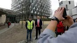 Seorang pekerja berfoto bersama lilin Madame Tussauds Presiden AS Donald Trump yang dipajang di luar Kedutaan Besar AS yang baru di Nine Elms, London (12/1). Menurutnya gedung kedutaan sebelumnya berada di lokasi terbaik. (AP Photo / Alastair Grant)
