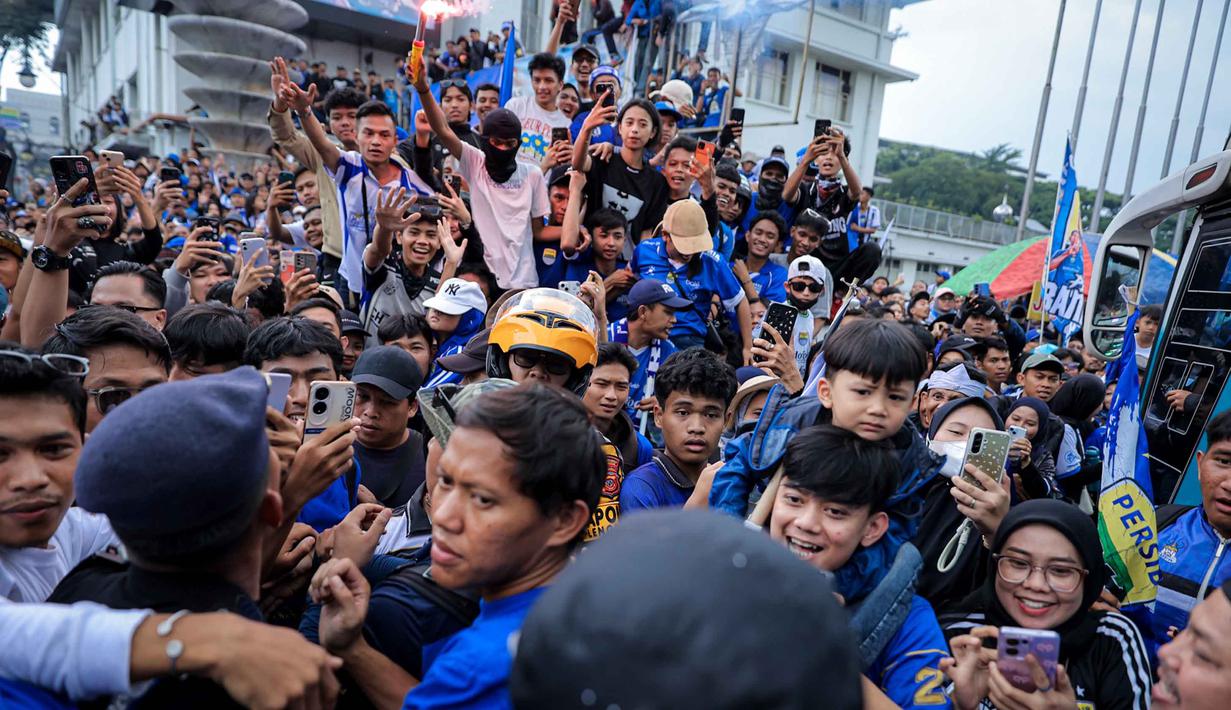 Warga menyambut tim dan ofisial Persib Bandung saat pawai perayaan gelar juara BRI Super League 2025/2026 di Bandung, Jawa Barat, Minggu (24/5/2026). (Bola.com/Bagaskara Lazuardi)