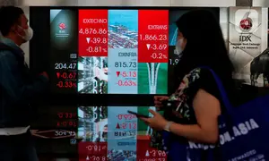 Pekerja tengah melintas di bawah layar Indeks harga saham gabungan (IHSG) di BEI, Jakarta, Selasa (16/5/2023). (Liputan6.com/Angga Yuniar)