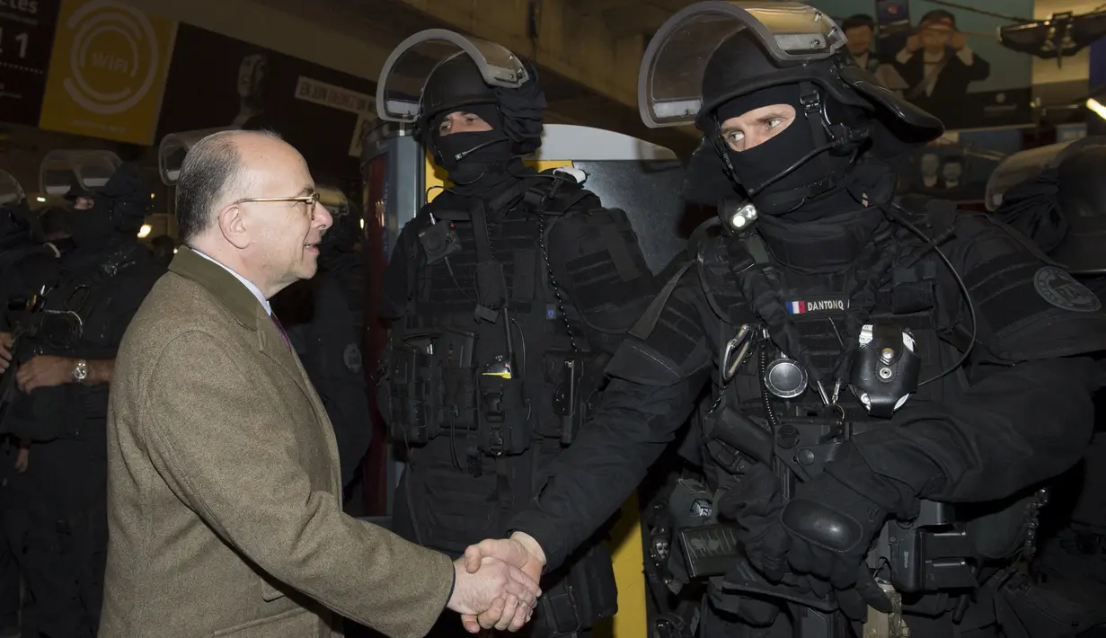 Menteri Dalam Negeri Prancis Bernard Cazeneuve (kiri) berjabat tangan dengan anggota dari Recherche Bantuan Intervensi penasihatan (RAID) setelah latihan dalam kasus serangan teroris di la Gare Montparnasse, Paris (20/4). (REUTERS/MIGUEL MEDINA)