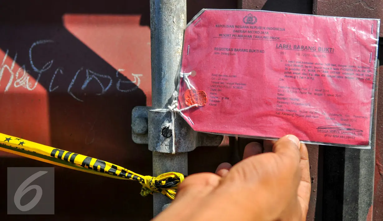Petugas menunjukan label barang bukti yang dipasang di kontainer berisi pupuk ilegal di Pelabuhan Tanjung Priok, Jakarta, Kamis (7/4/2016). Sebanyak 6 kontainer pupuk ilegal berhasil diamankan pihak berwajib. (Liputan6.com/Yoppy Renato)