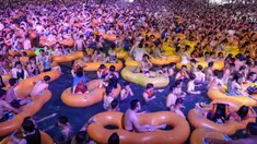 Foto pada 15 Agustus 2020 memperlihatkan orang-orang menonton pertunjukan musik sambil bermain air di sebuah taman air atau water park di Wuhan, provinsi Hubei, China. Mereka berpesta saat Wuhan kembali ke kehidupan normal setelah sempat terdampak parah oleh COVID-19. (STR/AFP)