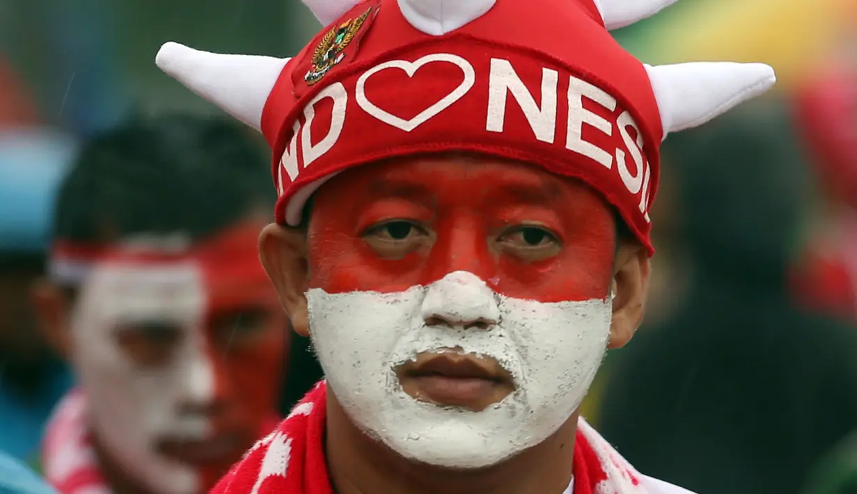 Sorang pendukung Tim Nasional Indonesia lengkap dengan atributnya bersiap menonton pertandingan final leg pertama Piala AFF 2016 di Stadion Pakansari, Bogor, Rabu (14/12). (Liputan6.com/Johan Tallo)