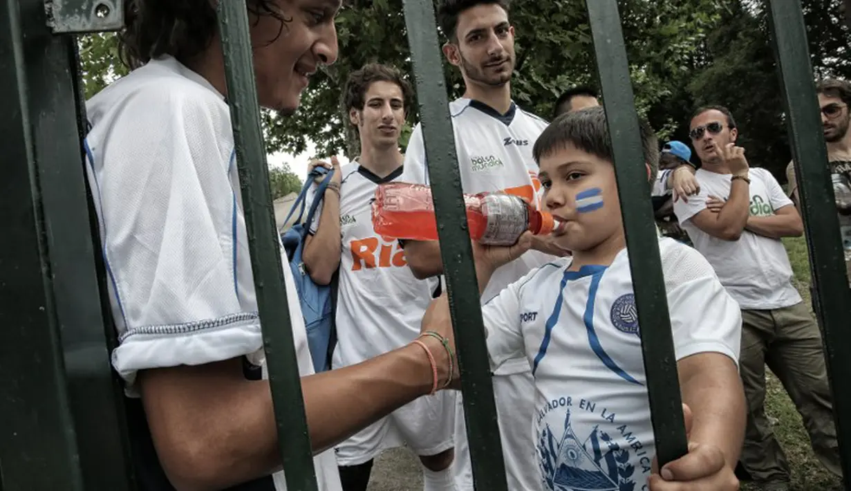 Suporter Salvador saat berada di turnamen sepak bola untuk kaum migran dan orang asing bertajuk "Balon Mundial" yang dihelat 6 Juni-5 Juli 2015 di Turin, Italia. (AFP PHOTO/MARCO BERTORELLO)