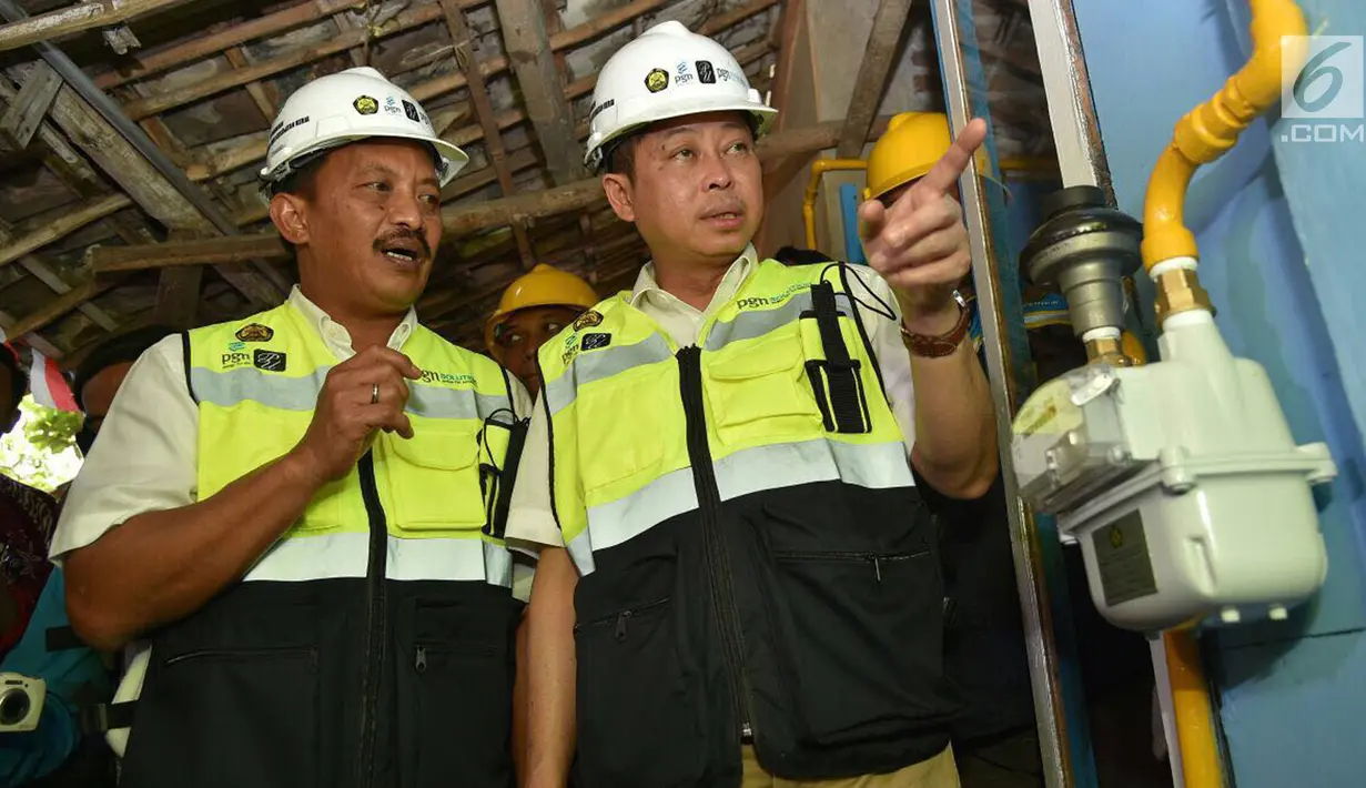 Menteri ESDM Ignasius Jonan dan Dirut PT Perusahaan Gas Negara (PGN) Jobi Triananda Hasjim saat melihat jaringan gas bumi rumah tangga di Kecamatan Prajurit Kulon, Mojokerto, Jawa Timur (13/8). (Liputan6.com/Pool)