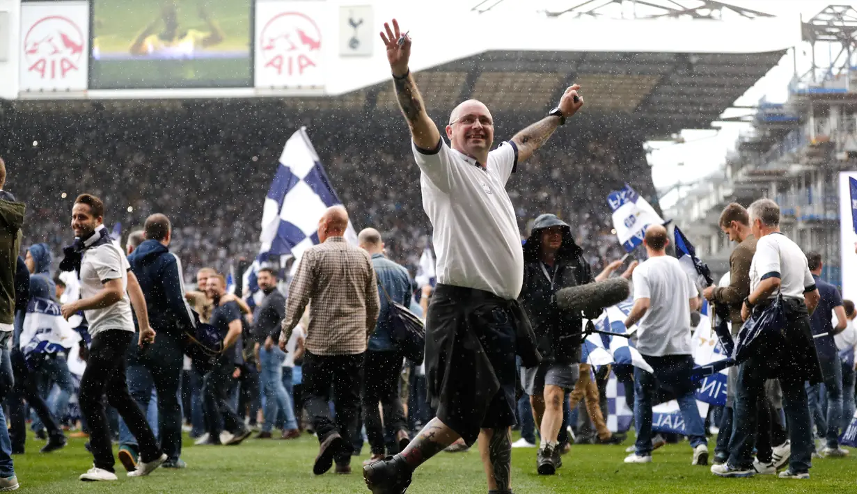 Seorang fans saat berada di lapangan usai pertandingan Tottenham Hotspur melawan MU di stadion White Hart Lane, London, (14/5). Pertandingan Spurs di Stadion ini merupakan yang terakhir dan akan pindah ke stadion baru. (AP/Frank Augstein)