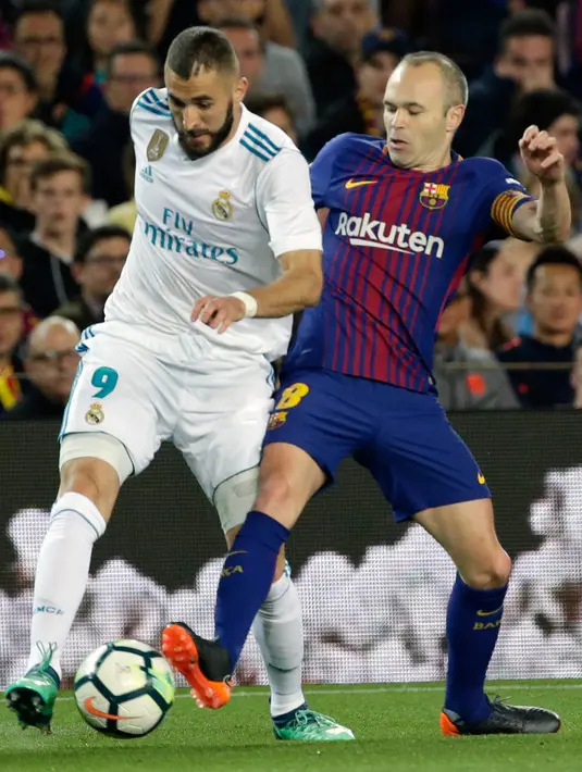 Pemain Barcelona, Andres Iniesta berebut bola dengan pemain Real Madrid, Karim Benzema pada pertandingan La Liga Spanyol di Stadion Camp Nou, Minggu (6/5). Barcelona bisa memaksakan hasil imbang dengan Real Madrid 2-2. (AP/Emilio Morenatti)