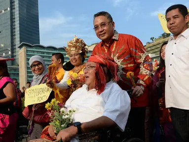 Menteri Desa, PDT dan Transmigrasi Eko Sandjojo mendorong kursi roda budayawan Wimar Witoelar saat mengikuti pawai budaya memperingati Hari Internasional Masyarakat Adat se-Dunia di Bundaran HI, Jakarta, Minggu (7/8). (Liputan6.com/Angga Yuniar)