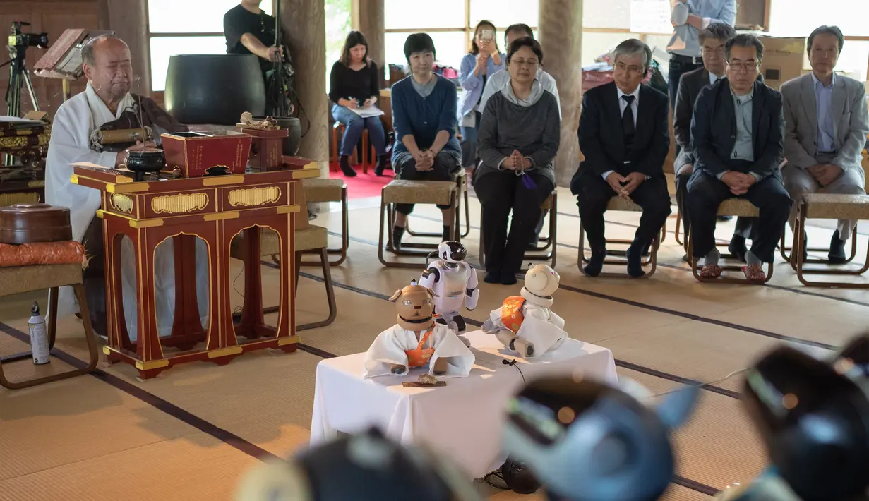 Pemuka agama, Bungen Oi memimpin upacara pemakaman untuk robot peliharaan Sony AIBO yang dipajang di altar kuil Kofukuji di Isumi, Kamis (26/4). Robot anjing yang sudah rusak itu dimakamkan dalam upacara pemakaman layaknya manusia. (AFP/Nicolas Datiche)