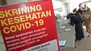 Pengunjung mengisi formulir pernyataan kesehatan sebelum memasuki Rumah Sakit Siloam, Jakarta, Sabtu (7/3/2020). RS Siloam menyediakan fasilitas tenda isolasi sementara, ruangan dekontaminasi dan pengecekan suhu tubuh guna mengantisipasi penyebaran virus corona. (Liputan6.com/Herman Zakharia)