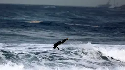 Seorang peserta melompat setelah berhasil menaklukan ombak selama mengikuti dalam kompetisi surfing di laut Mediterania di Ashdod, Israel, (17/11). (REUTERS/Amir Cohen)