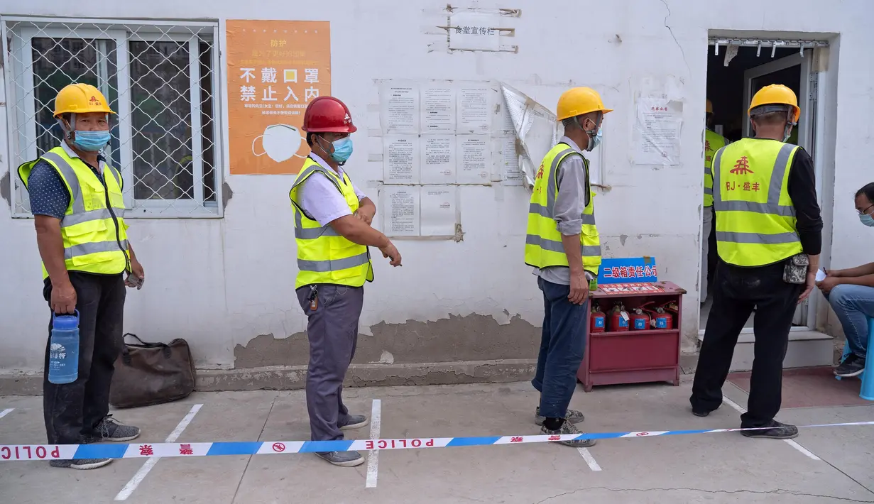 Para pekerja konstruksi berbaris mengantre di lokasi pengambilan sampel sementara di Distrik Daxing, Beijing, China (2/7/2020). Sebanyak 1.353 pekerja di lokasi konstruksi tersebut menjalani pengambilan sampel tes asam nukleat pada Kamis (2/7). (Xinhua/Cai Yang)