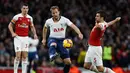 Penyerang Tottenham, Harry Kane mencoba melewati Sokratis Papasthatopaulus dalam laga lanjutan Liga Inggris pekan ke-14 yang berlangsung di stadion Emirates, London, Minggu (2/12). Tottenham Hotspur kalah 1-2 atas Arsenal. (AFP/Ian Kington)