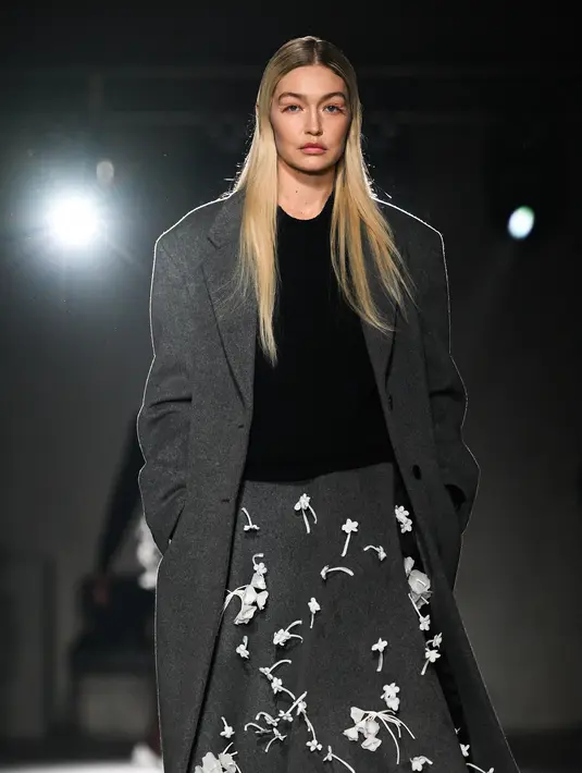Gigi Hadid mempersembahkan kreasi Prada selama Koleksi Wanita Musim Gugur-Musim Dingin 2023-2024 sebagai bagian dari Fashion Week di Milan pada 23 Februari 2023. Gigi mengangkat tinggi badannya dengan sepasang sepatu hak tinggi dengan motif bunga Kendall berwarna biru pucat. Model itu mengenakan rambut pirang panjangnya yang diluruskan dan mengalir di bahunya. (AFP/Marco Bertorello)