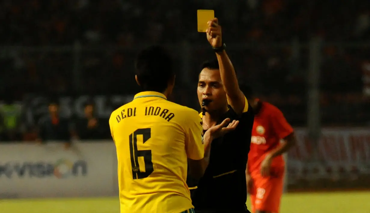 Dedi Indra (Gresik United) harus mendapat kartu kuning dari wasit Handri Kristanto saat berlaga melawan Persija di stadion GBK Jakarta, (29/4/2014). (Liputan6.com/Helmi Fithriansyah)