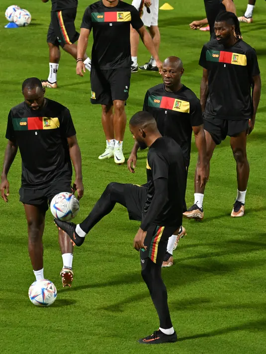 Penyerang Kamerun #06 Nicolas Moumi Ngamaleu (Kiri) ambil bagian dalam sesi latihan di Al Sailiya SC di Doha, Kamis (1/12/2022).  Timnas Kamerun akan menghadapi Timnas Brasil di Lusail Iconic Stadium pada matchday 3 Grup G Piala Dunia 2022, Sabtu, 3 Desember 2022 dini hari WIB. (ISSOUF SANOGO / AFP)