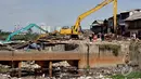 Sebuah alat berat digunakan untuk menghancurkan rumah warga saat penggusuran pemukiman di pinggir Waduk Pluit, Jakarta, Minggu (11/1/2015). (Liputan6.com/Faizal Fanani)
