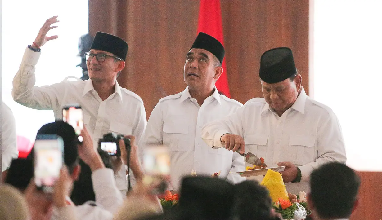 Ketua Umum Partai Gerindra, Prabowo Subianto (kanan) memotong tumpeng disaksikan Wakil Ketua Dewan Pembina Partai Gerindra Sandiaga Uno (kiri) dan Sekretaris Jenderal Gerindra Ahmad Muzani (tengah) saat perayaan HUT ke-15 Partai Gerindra, di Kantor DPP Partai Gerindra, Jakarta, Senin (6/2/2023). HUT ke-15 Partai Gerindra merupakan momen berharga karena dilaksanakan sebelum Pemilu 2024 dan juga untuk melakukan konsolidasi internal untuk semakin memperkuat kekuatan partai. (Liputan6.com/Faizal Fanani)
