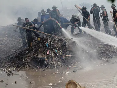 Personel TNI bersama pemadam kebakaran dan masyarakat membersihkan sampah Sungai Ciliwung, Kampung Melayu, Jakarta, Selasa (2/12/2014). (Liputan6.com/Faizal Fanani)