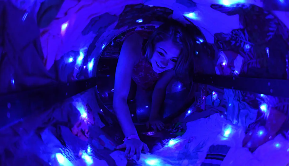 Seorang anak melewati lorong ruangan objek wisata Meow Wolf di sebuah tempat bekas arena bowling tua di Santa Fe, New Mexico (31/7). Objek wisata dan pameran instalasi ini dikunjungi oleh ratusan ribu orang. (AFP Photo/Mark Ralston)