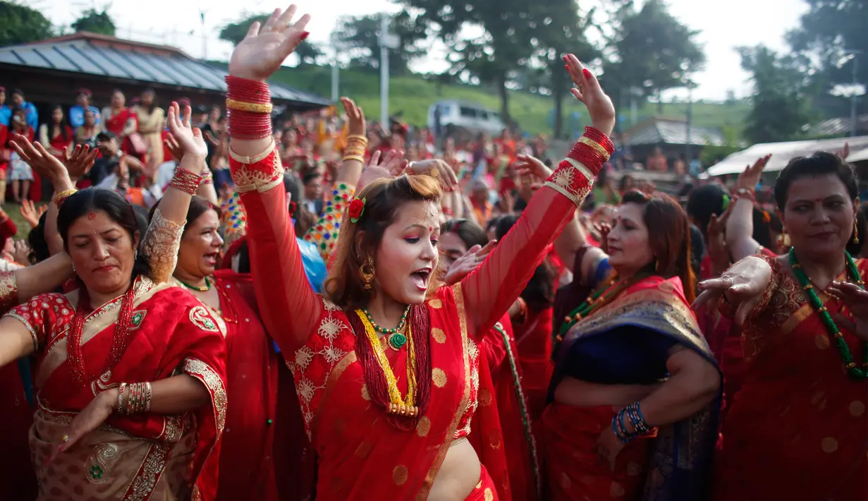 Wanita Hindu Nepal menari di kuil Pashupatinath selama festival Teej di Kathmandu, Nepal, Kamis (24/8). Festival ini ditujukan untuk wanita Hindu Nepal yang selama perayaan wajib berpuasa dan berdoa untuk kebahagiaan sang suami. (Niranjan Shrestha/AP)