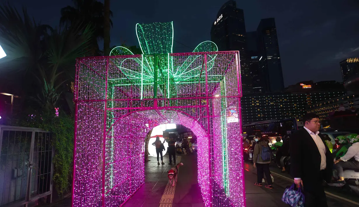 Jakarta Light Festival 2025 dirancang untuk menciptakan suasana hangat akhir tahun, sekaligus menjadi daya tarik bagi masyarakat untuk menikmati pemandangan malam Jakarta. Tampak dalam foto, warga menikmati suasana Jakarta Light Festival 2025 di sekitar Bundara Hotel Indonesia, Jakarta, Selasa (23/12/2025). (Kapanlagi.com/Budy Santoso)