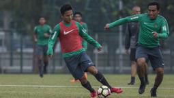 Pemain Timnas Indonesia, Syahrian Abimanyu menghindari kejaran Bima Sakti saat latihan di Lapangan ABC Senayan, Jakarta, Sabtu (17/3/2018). Latihan ini merupakan persiapan jelang laga uji coba melawan Singapura. (Bola.com/Vitalis Yogi Trisna)