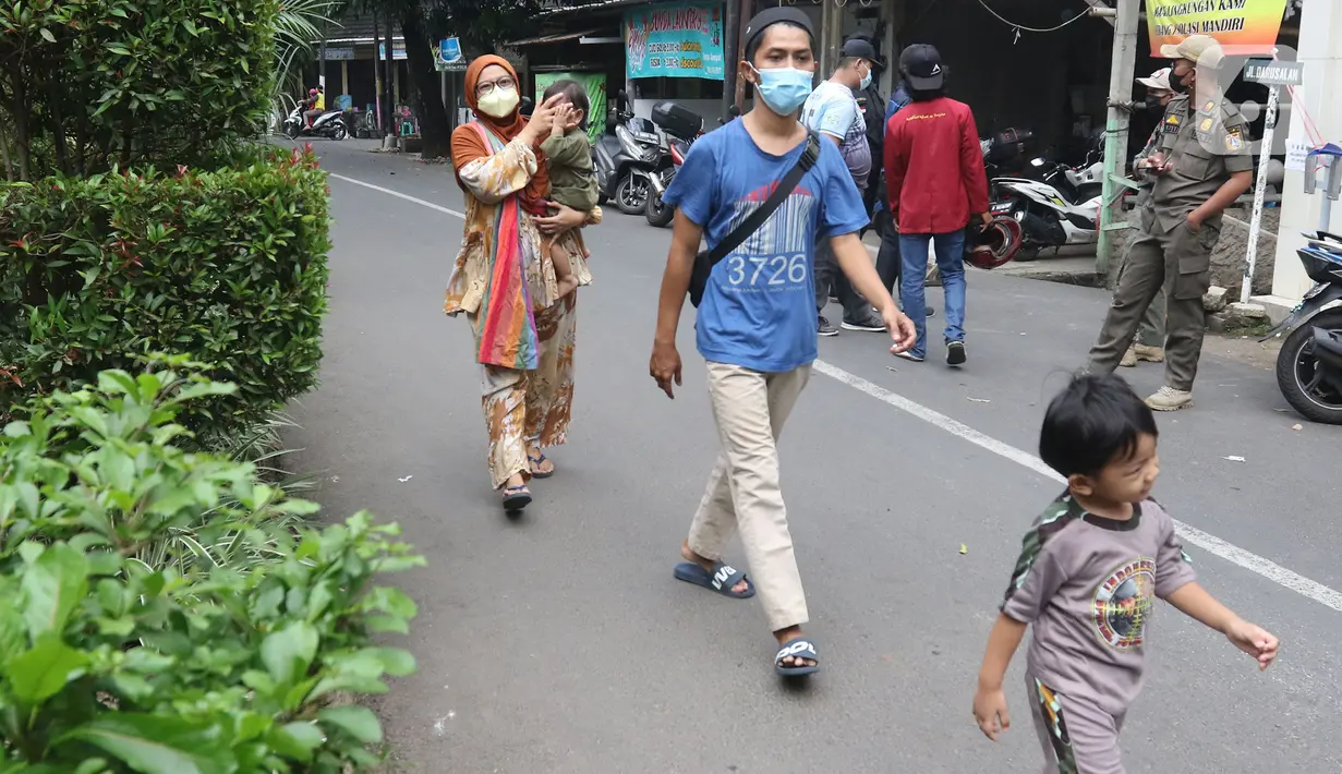 Warga saat akan dibawa ke wisma atlet di Jalan As-Syafiiyah, Cipayung, Jakarta, Jumat (21/5/2021). 20 warga diantaranya 17 orang bergejala ringan dibawa ke Wisma Atlet, 3 orang bergejala sedang dibawa ke RSUD Ciracas dan 12 orang OTG isolasi mandiri. (Liputan6.com/Herman Zakharia)