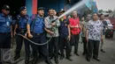 Wagub DKI Djarot Saiful Hidayat mencoba semprotan pemadam ketika mengunjungi Kantor Dinas Pemadam Kebakaran di Jalan KH Zainul Airifin, Jakarta, Sabtu (8/10). Djarot memantau kesiapan anggota dan peralatan pemadam kebakaran (Liputan6.com/Faizal Fanani)