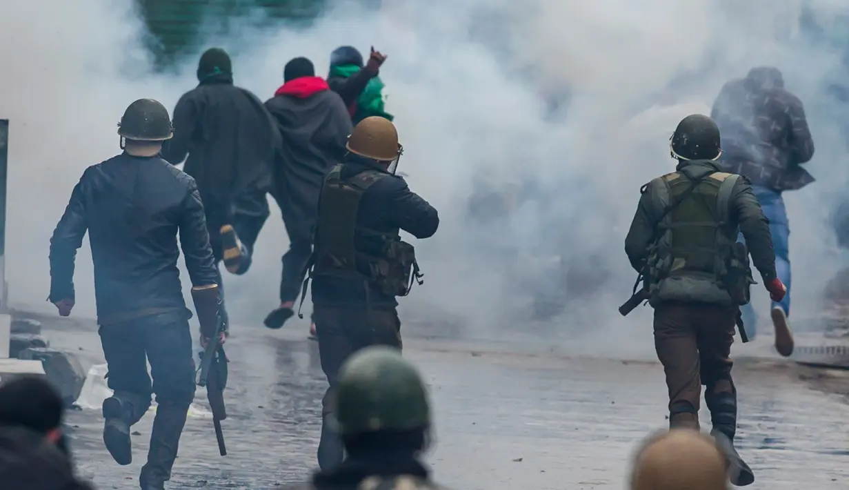 Petugas menembakkan gas air mata untuk membubarkan demonstran di Srinagar, Kashmir, India, Jumat (3/2). Demonstran memprotes hukuman mati yang diberikan oleh pengadilan Kolkata terhadap seorang pria Kashmir bernama Muzaffar Ahmed. (AP Photo / Dar Yasin)
